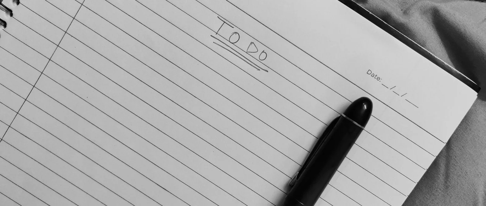 Black pen resting on an open notebook with a handwritten to-do list